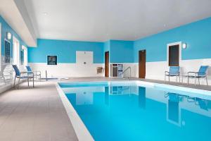 a large swimming pool with blue walls and chairs at Four Points by Sheraton Regina in Regina