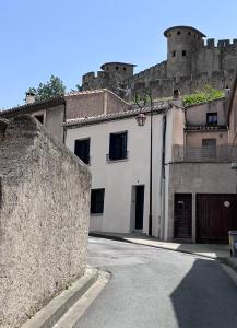 une rue vide en face d'un château dans l'établissement La maison rue Nadaud, au pied des remparts, à Carcassonne