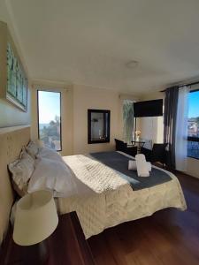 a large bedroom with a large bed and two windows at Hotel 251 in Viña del Mar