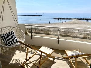 a balcony with chairs and a view of a beach at Appartement Elida vue mer in Palavas-les-Flots