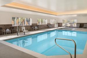 uma piscina num hotel com cadeiras e mesas em TownePlace Suites by Marriott Logan em Logan