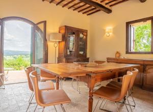 uma sala de jantar com uma mesa de madeira e cadeiras em Podere Bargnano Cetona, Sleeps 14, Pool, WiFi, Air conditioning em Cetona
