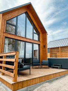 una casa con una terraza de madera con muebles. en Casas de la Playa, en Kunice