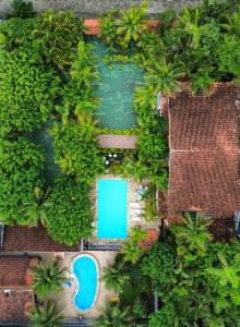 an overhead view of a swimming pool with palm trees at Pousada Chez Soleil CibrateI Itanhaém in Itanhaém