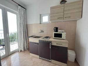 een kleine keuken met een wastafel en een magnetron bij Apartment Lira 2 in Mlini