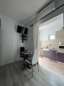 een woonkamer met een tafel en stoelen en een keuken bij Apartment Lira 2 in Mlini