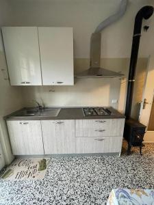 a kitchen with white cabinets and a stove top oven at La casa di John in Finale Ligure