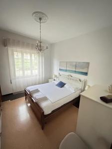 a bedroom with a bed and a chandelier at La casa di John in Finale Ligure