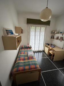 Schlafzimmer mit einem Bett, einem Schreibtisch und einem Fenster in der Unterkunft La casa di John in Finale Ligure