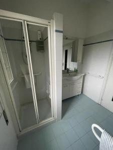 a bathroom with a glass shower and a sink at La casa di John in Finale Ligure