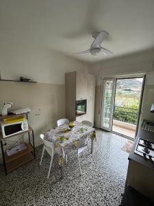 ein Esszimmer mit einem Tisch, Stühlen und einem Fenster in der Unterkunft La casa di John in Finale Ligure