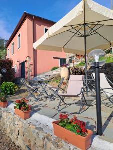 a patio with a chair and an umbrella and flowers at Agriturismo A' Taversa in Levanto