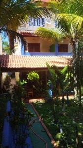 una casa con un jardín con una manguera delante en Pousada Chez Soleil CibrateI Itanhaém, en Itanhaém