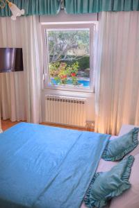 a bedroom with a blue bed and a window at Villa Sviba in Split +40 photos