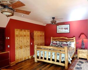 a bedroom with red walls and a wooden bed at Dream Drift Motel in Cameron