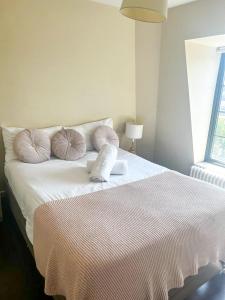 una camera da letto con un letto bianco e cuscini sopra di Flat 1 a Hendon