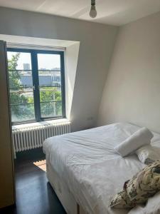 a bedroom with a bed and a large window at Flat 1 in Hendon