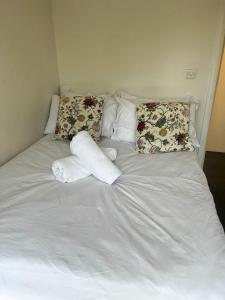 a white bed with pillows and towels on it at Flat 1 in Hendon