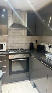 y cocina con fogones y microondas. en Flat 1 en Hendon