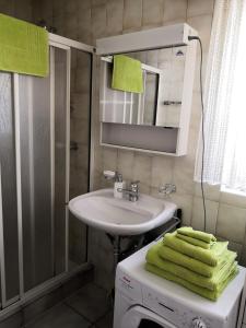 a bathroom with a sink and a mirror and towels at Apartment am Birkenweg 