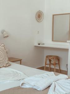 a bedroom with a bed with a mirror and a stool at Lindos Athena in Lindos