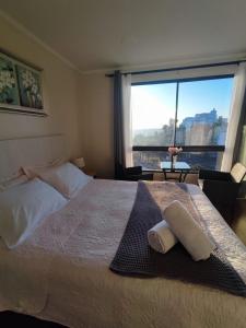 um quarto com uma cama grande e uma janela grande em Hotel 251 em Viña del Mar