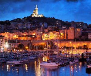 un groupe de bateaux amarrés dans un port la nuit dans l'établissement Marseille élégance Appartement 2 chambres Climatisé 60 m2 de confort et Proximité, à Marseille