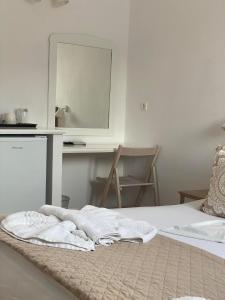 a bedroom with a bed with a mirror and a desk at Lindos Athena in Lindos
