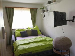 a bedroom with a bed with green sheets and a window at Apartment am Birkenweg 