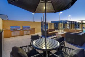 a patio with a table and chairs and an umbrella at TownePlace Suites Las Vegas Airport South in Las Vegas