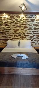 a bed in a room with a stone wall at Chalkidiki AsterGia apartments in Metangítsion