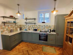 uma cozinha com armários verdes e um fogão forno superior em Cozy apartment with a garden view in the 17th quartier em Paris