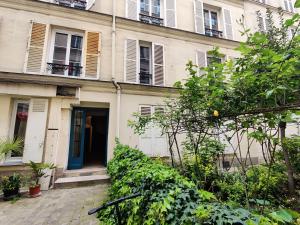 um edifício de apartamentos com uma porta azul e janelas em Cozy apartment with a garden view in the 17th quartier em Paris