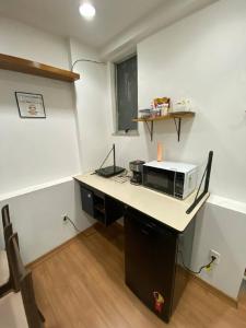 a kitchen with a desk with a microwave on it at Vai ser feliz in Rio de Janeiro