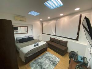 1 dormitorio con 1 cama grande y 1 sofá en Vai ser feliz en Río de Janeiro