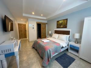 1 dormitorio con cama, escritorio y lavamanos en Noe Hotel ,1 Bed Room 2 Near to the beach en Punta Cana