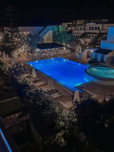 a large blue swimming pool with chairs and umbrellas at Lindos Athena in Lindos