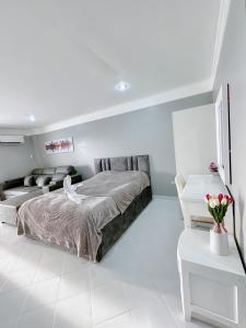a white bedroom with a bed and a couch at Sea sand sun Condominiums in Rayong
