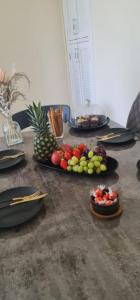 a table with plates of fruit on top of it at Stylish 2 Bed Flat in Hoxton near Art Galleries in London