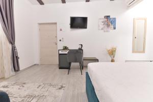 ein weißes Wohnzimmer mit einem Tisch und einem Stuhl in der Unterkunft Luxury Rooms "Kaleta" in Trogir