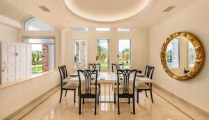 una sala da pranzo con tavolo, sedie e specchio di Crown Royal Luxury Villa Estates a Città di Rodi