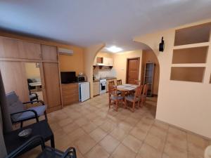 a kitchen and dining room with a table and chairs at Rozmaring Apartmanok in Gyula