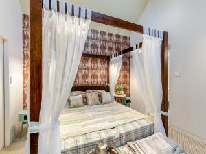 Schlafzimmer mit Himmelbett und weißen Vorhängen in der Unterkunft The Stables in Longridge
