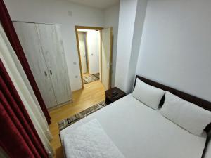 een slaapkamer met een wit bed en een spiegel bij Vila Vlasina in Vlasina Rid