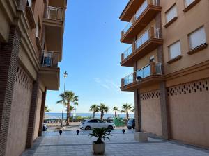 a car is parked in a parking lot between two buildings at Balcón de la Torre del Morche en Torrox Costa in El Morche