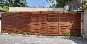 a wooden fence with potted plants on it at Magnolia apartman in Eger