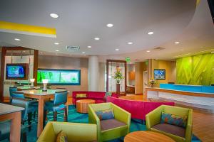 um átrio do hotel com mobiliário colorido e um bar em SpringHill Suites by Marriott Canton em North Canton