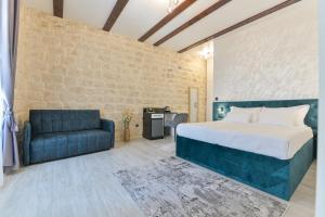 1 dormitorio con 1 cama y 1 sofá azul en Luxury Rooms "Kaleta", en Trogir