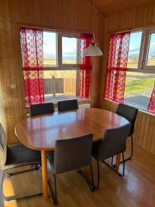 een eetkamer met een houten tafel en stoelen bij Víðilundur 17 in Varmahlid