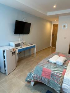 Habitación con 2 camas y escritorio con TV. en Noe Hotel ,1 Bed Room 2 Near to the beach, en Punta Cana